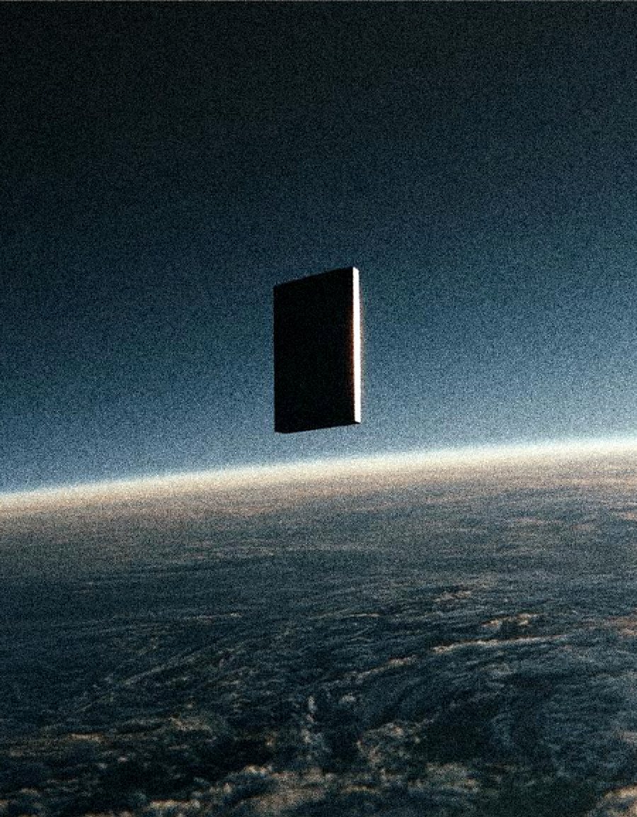 A black monolith in orbit with a hairline of sunlight on its edge above the Earth limb